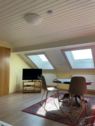 Fernseher und Sitzbereich im großen Schlafzimmer des Dachgeschosses
