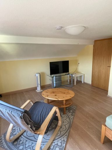 Schaukelstuhl und Fernseher im kleinen Dachgeschoss Schlafzimmer