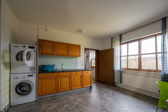 Waschküche mit Trockner, Waschmaschine und Arbeitsplatte mit Spülbecken